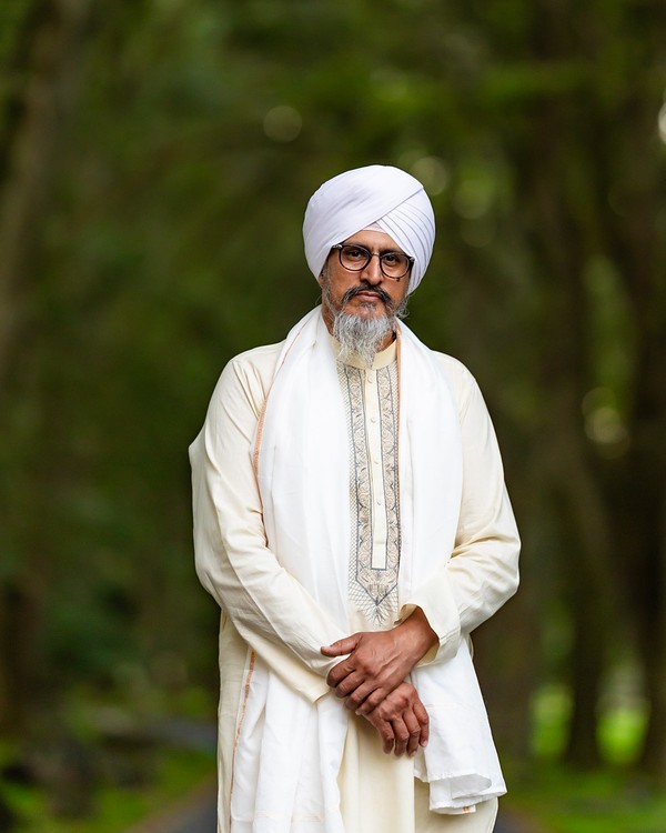 Dignified master portrait of Bhai Yadvinder Singh Ji, kirtani, sound engineer, and founder of Lion Beats Studio Auckland, wearing traditional white dastaar and hazuriya.